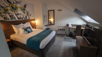 A hotel room with a bed, desk, and a large wall mural.