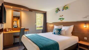 Ein Hotelzimmer mit Bett, Schreibtisch, Stuhl und einem großen Fenster.