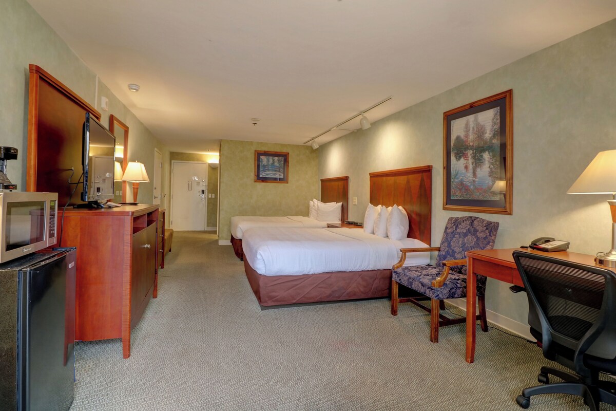 Une chambre d’hôtel équipée d’un lit, d’un bureau, d’une chaise et d’un téléviseur.