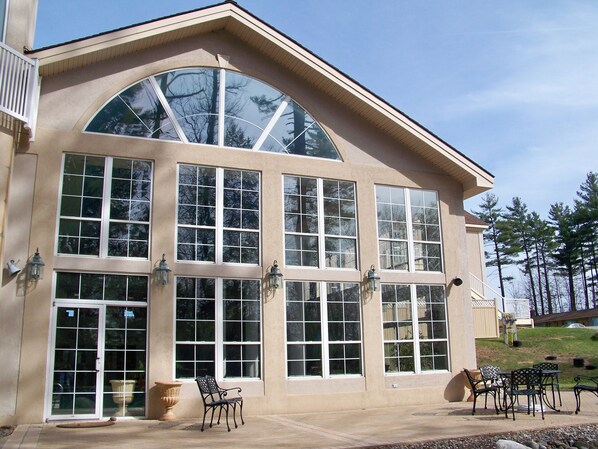 A large building with multiple windows and a patio area with outdoor furniture.