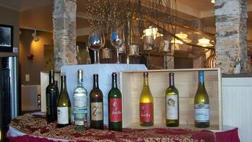 A wine display with bottles on a table, surrounded by birch tree trunks and decorative branches.
