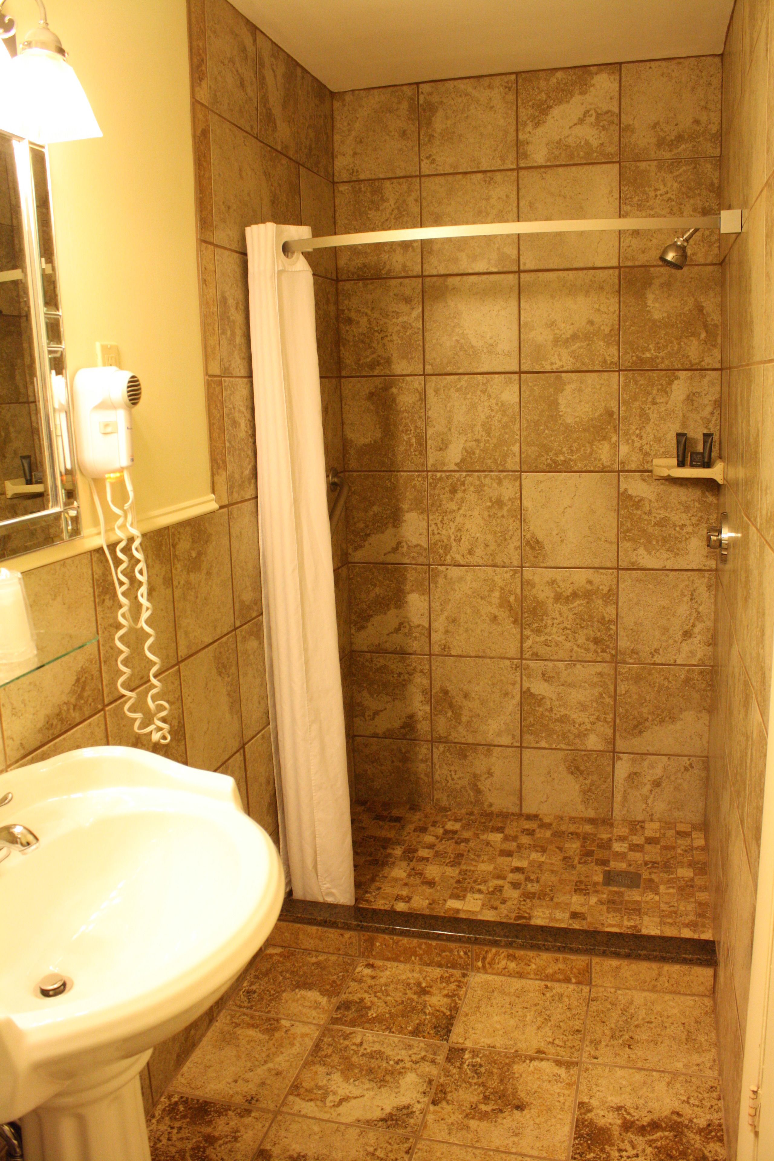 A bathroom with a shower, a sink, and a mirror.
