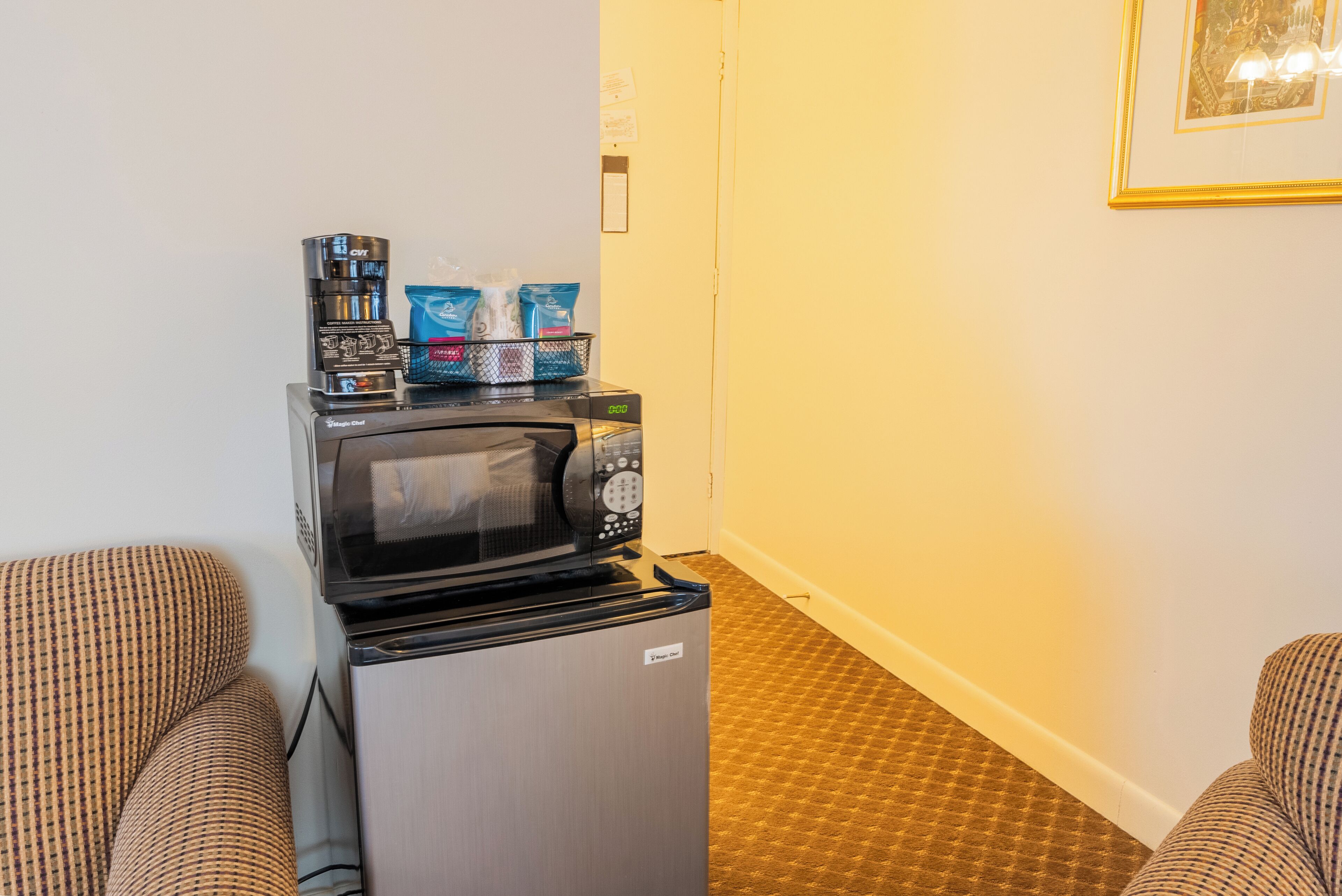 A compact kitchenette with a microwave, a small refrigerator, and a coffee maker.