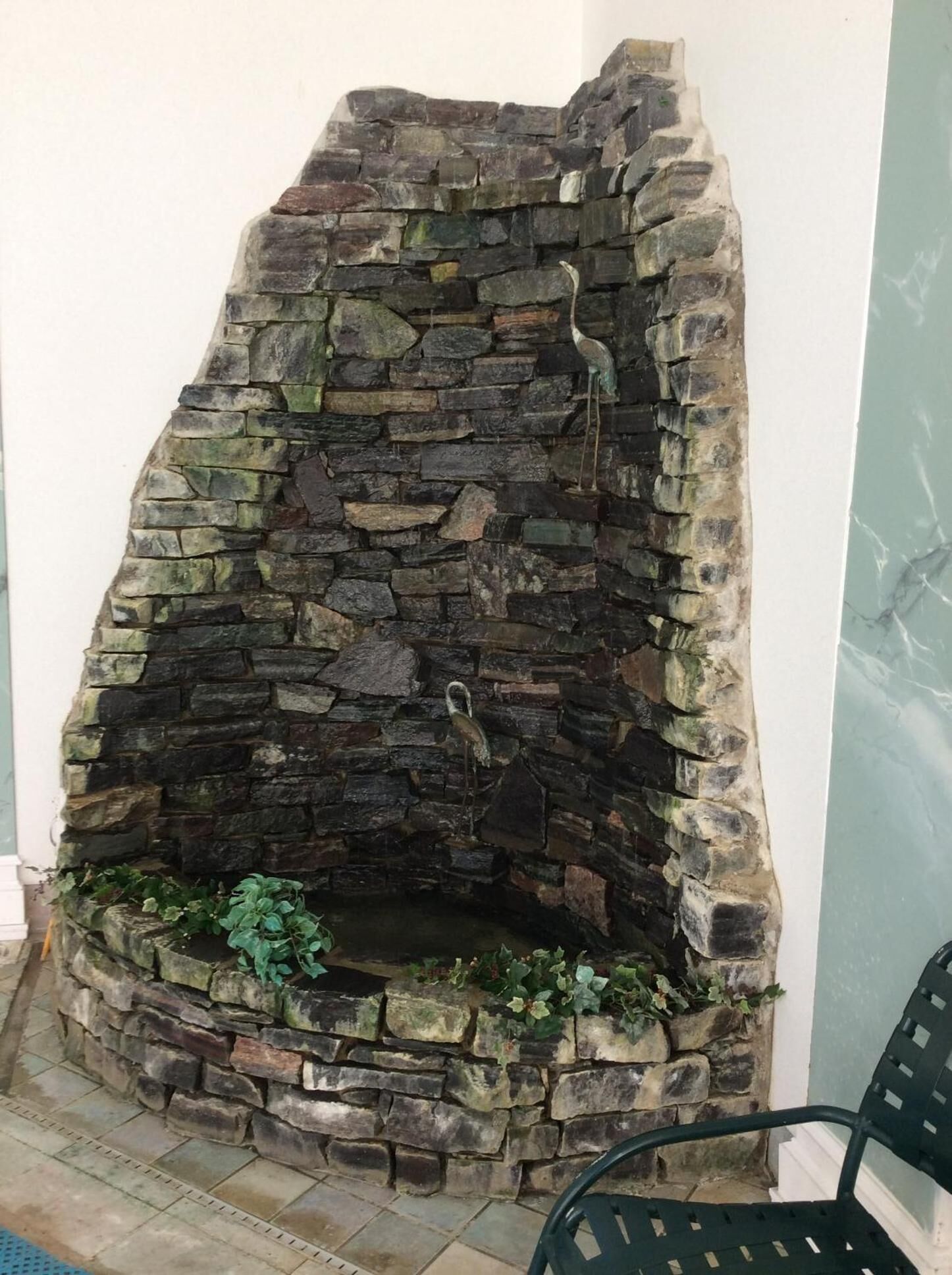 Un caminetto in pietra con una statuina di un uccello.
