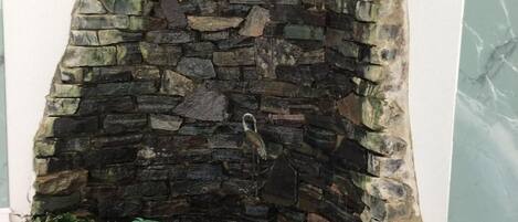 A stone fireplace with a bird figurine inside.