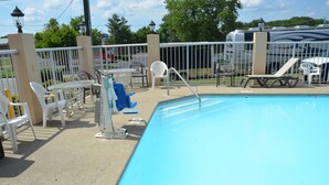 A swimming pool with a white fence, lounge chairs, and a covered area with tables and chairs. - Days Inn by Wyndham Nashville Airport (Nashville)