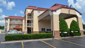 A multi-story hotel with a red roof, a covered entrance, and a parking lot. - Days Inn by Wyndham Nashville Airport (Nashville)