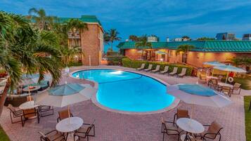 Una piscina al aire libre, sombrillas, sillones reclinables de piscina