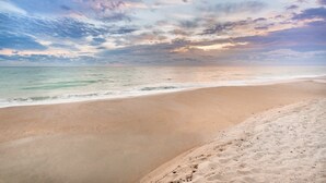 A beach with a wide sandy shore and gentle waves. - Ocean Breeze Inn Vero Beach (Vero Beach)