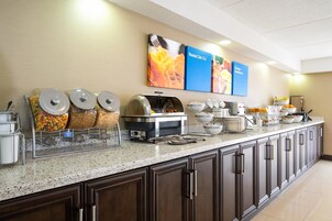 Montaje de bufé con diferentes recipientes de comida y una estación de café.