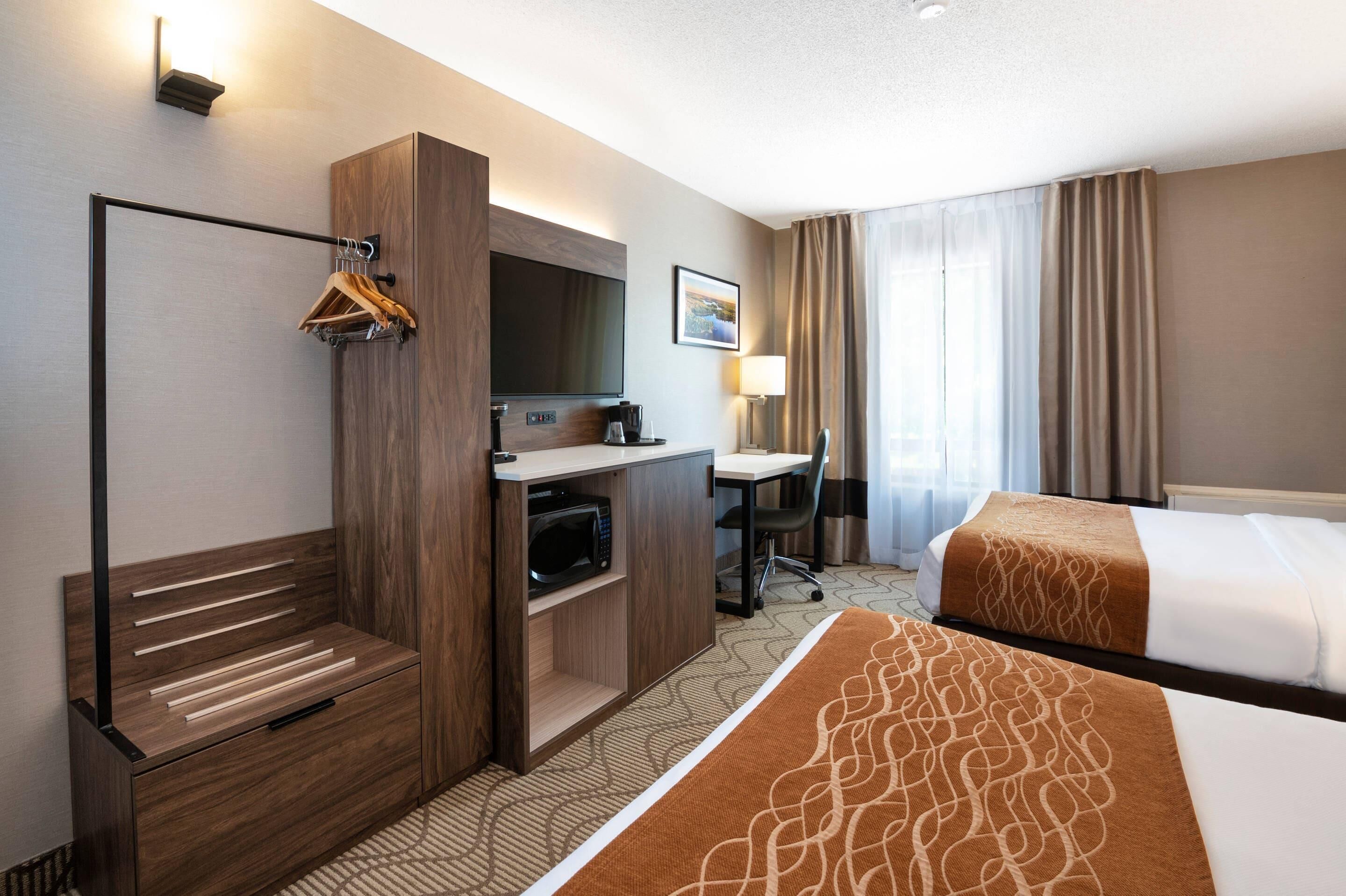 Une chambre d’hôtel équipée d’un lit, d’un bureau, d’une chaise et d’un téléviseur.