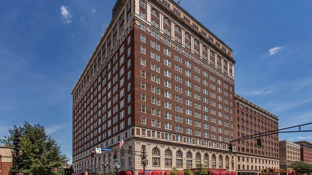 A large, multi-story hotel with a classic architectural style, featuring a symmetrical facade and numerous windows.