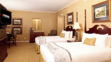 Habitación de hotel con dos camas, televisión, escritorio y silla.