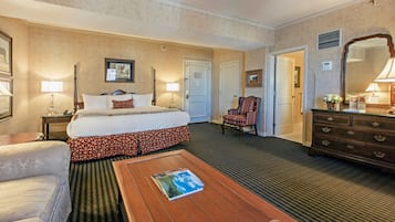 Ett hotellrum med en säng, en stol, en byrå, ett sängbord och ett soffbord.