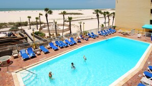 A swimming pool with blue lounge chairs and a view of the beach. - Bilmar Beach Resort (Treasure Island)