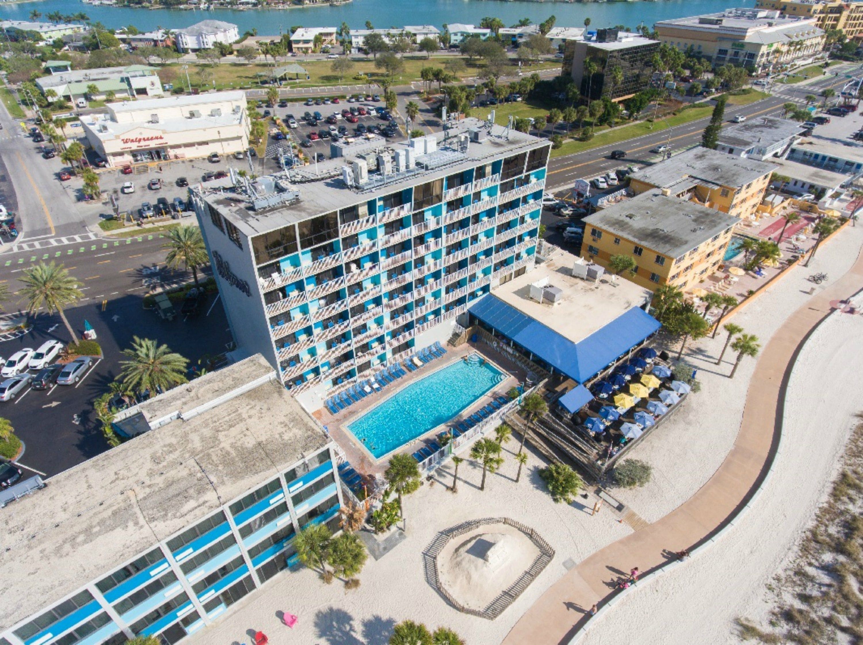 A multi-story hotel with a rooftop pool and a beachside location.