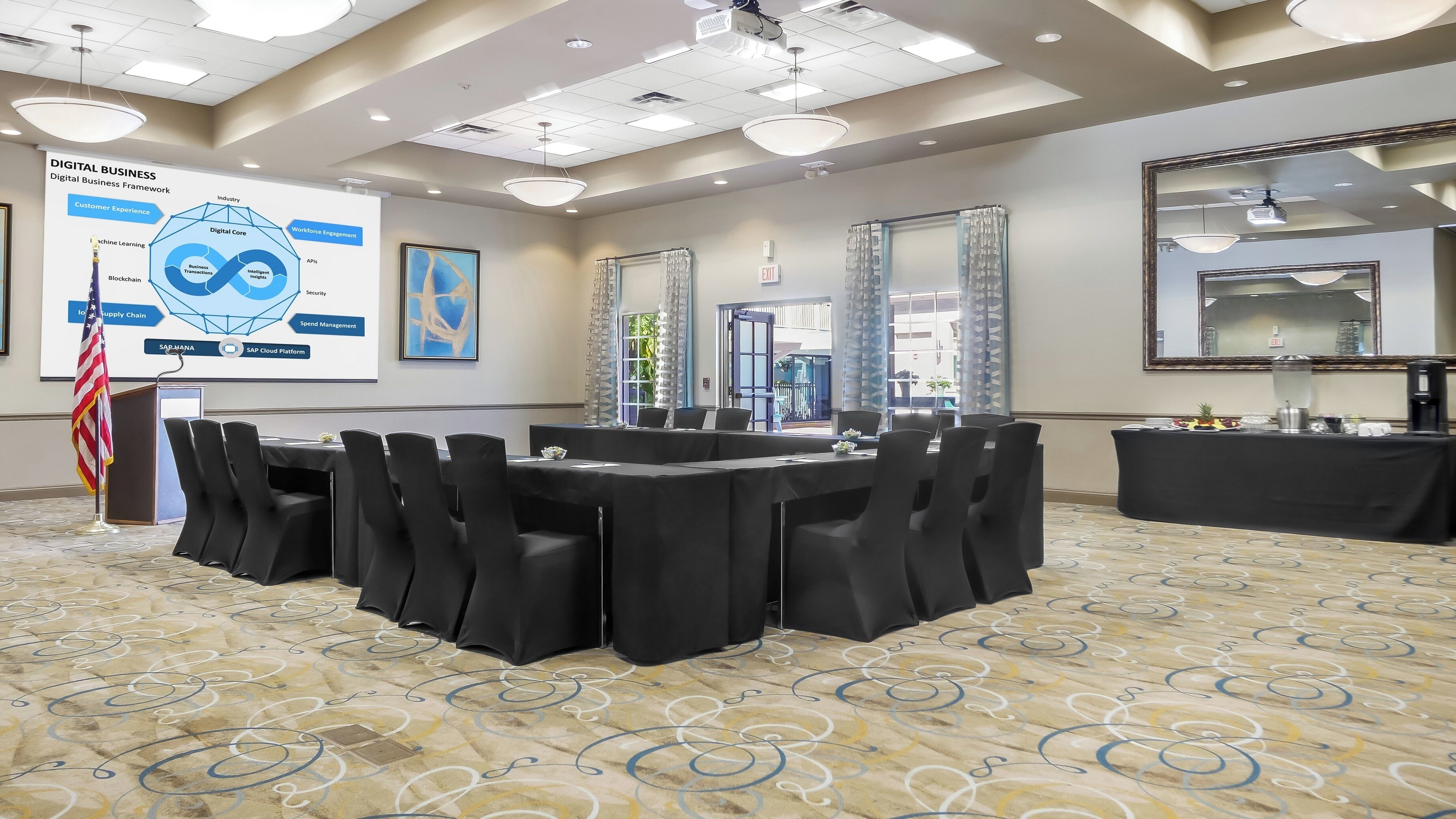 Une salle de conférence équipée d’un écran de présentation, d’un pupitre et d’une table avec des chaises.