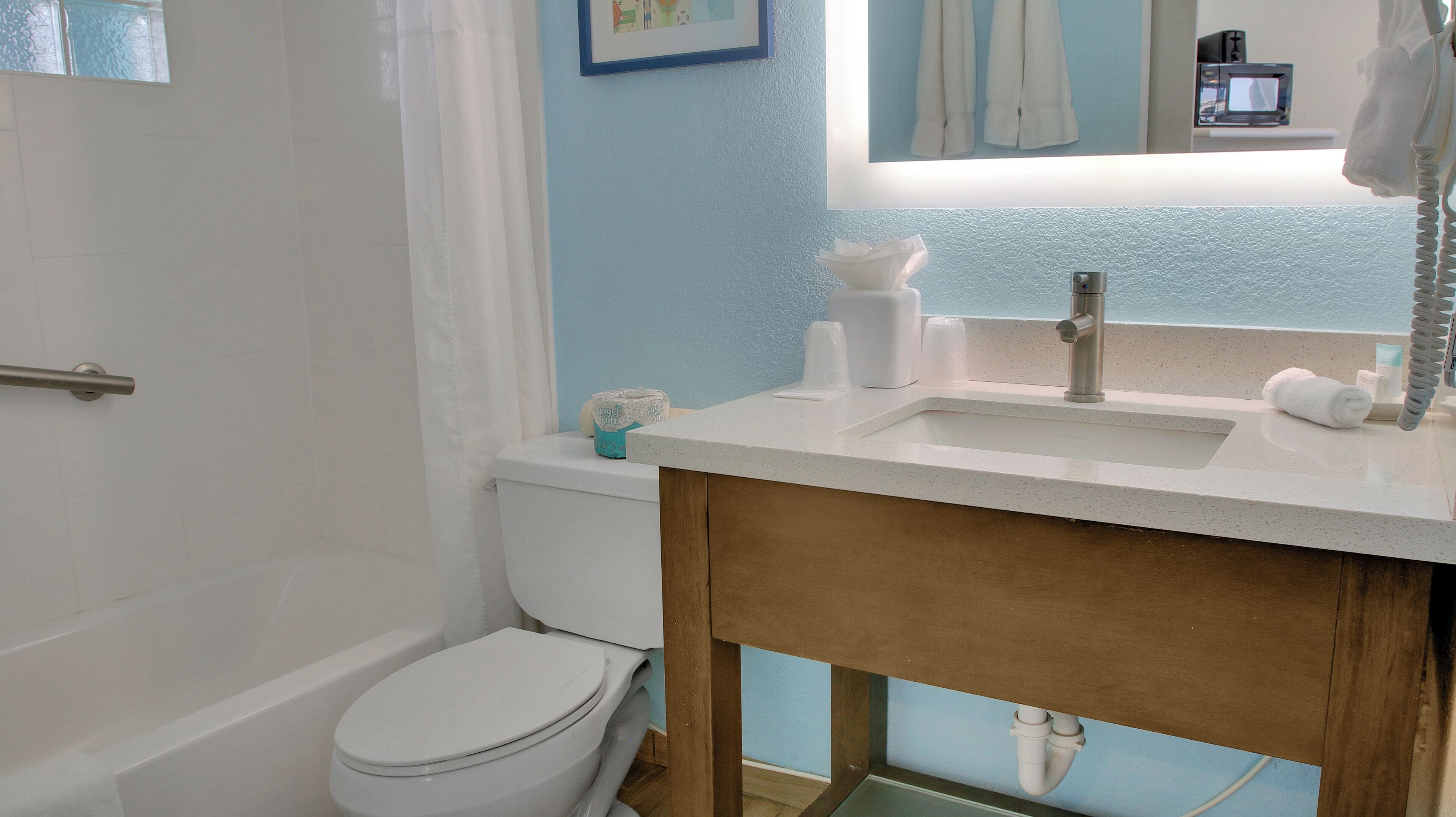 A bathroom with a toilet, sink, and shower.