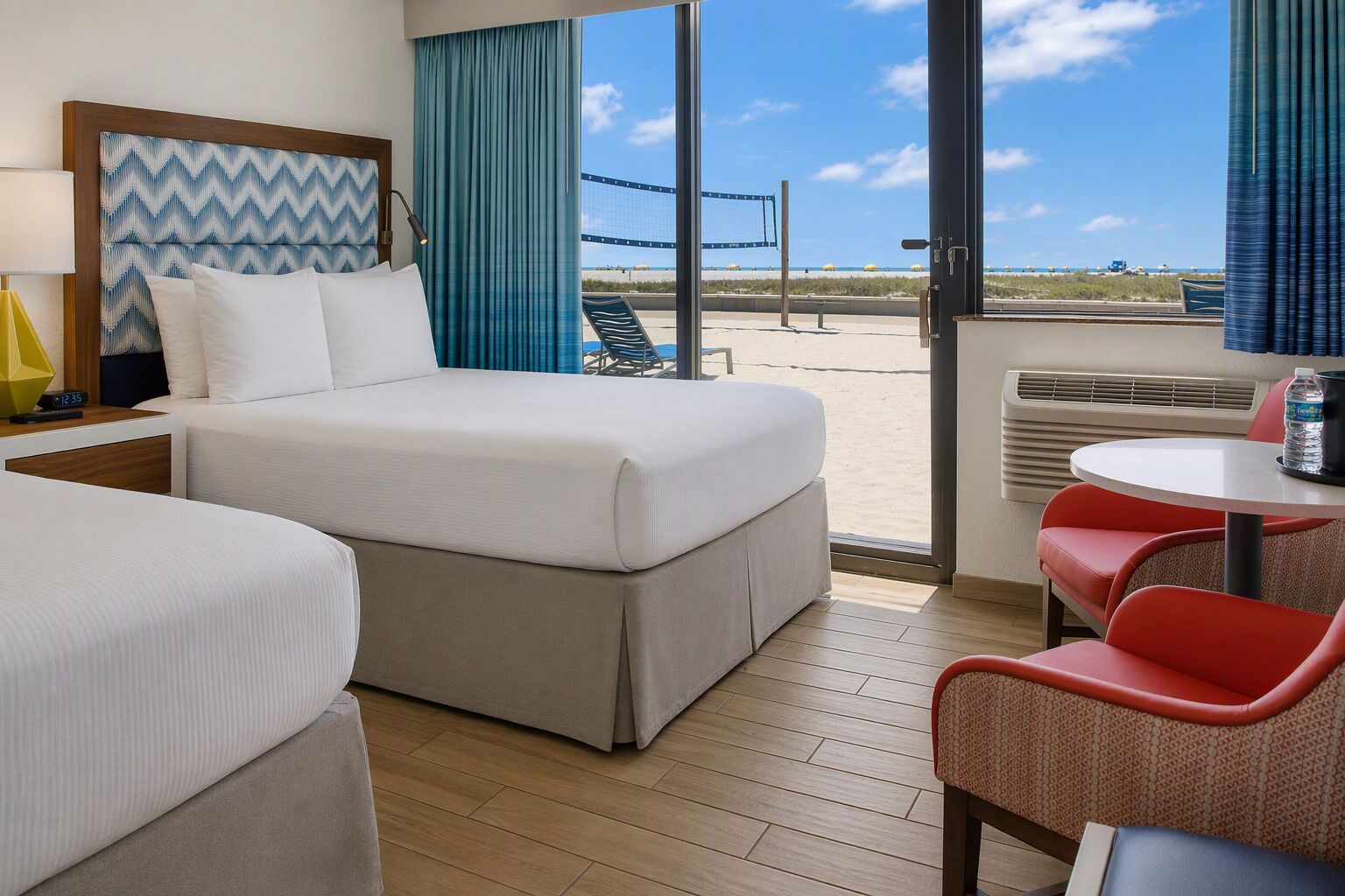 Habitación de hotel con cama, escritorio y vista al mar.