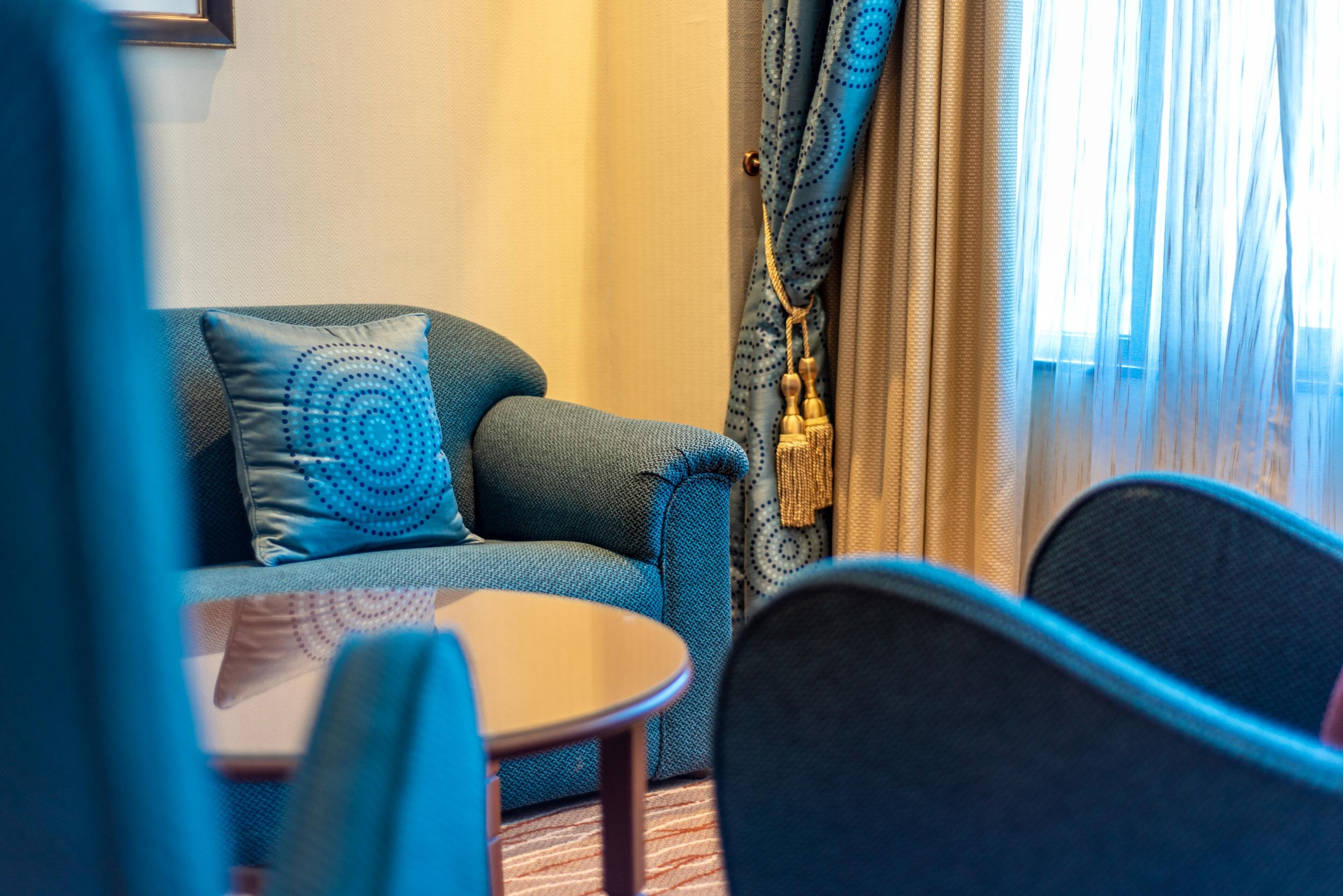 A room with a sofa, a small round table, and a chair.