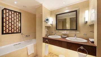 Un baño moderno con bañera, dos lavamanos, un espejo grande y un panel decorativo en la pared.
