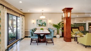 Un espace repas comprenant une grande table et des chaises, une plante en pot et une cheminée.