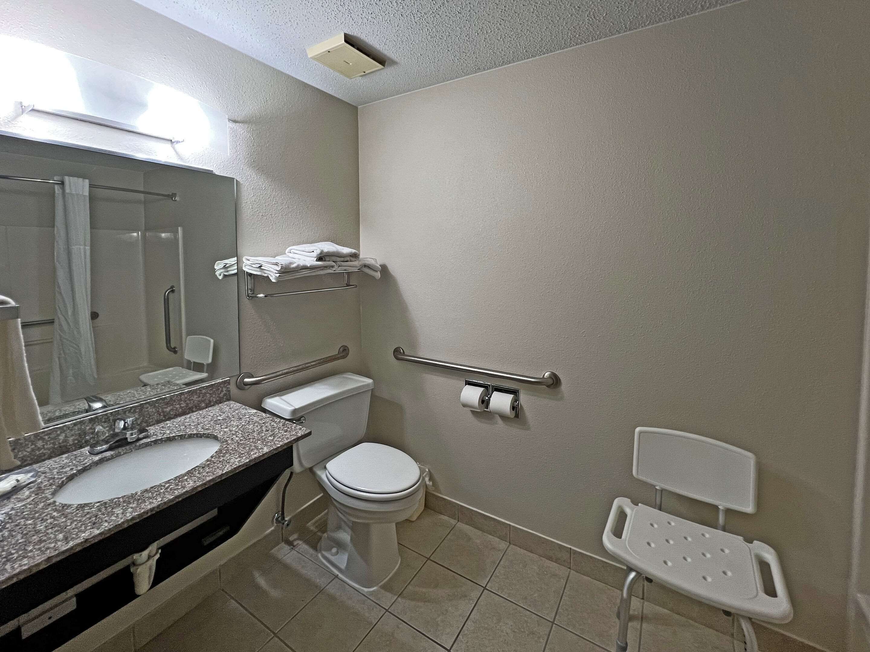 A bathroom with a sink, toilet, and a shower area.