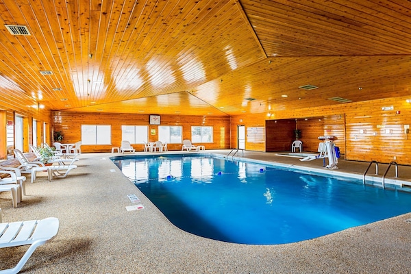 Een binnenzwembad, ligstoelen bij het zwembad