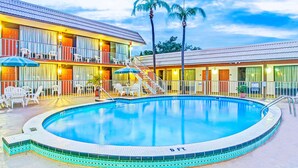 Ein Hotel mit Schwimmbad, Außenbereich und einer zweistöckigen Struktur.
