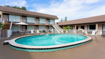 Un hôtel doté d’une piscine, d’un espace extérieur aménagé et d’un escalier menant à l’étage supérieur.