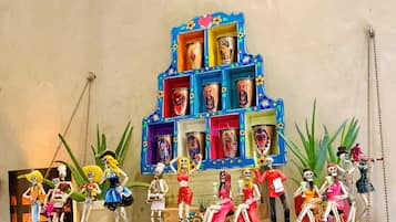 Una exhibición colorida de figuritas de esqueletos y un estante azul con fotografías.