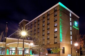Un hôtel Holiday Inn avec une façade en briques, de nombreuses fenêtres et une enseigne indiquant le nom de l’établissement.