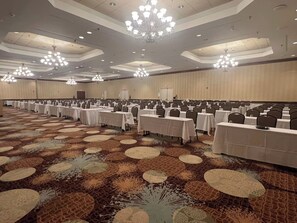 A large conference room with rows of tables and chairs, chandeliers, and a patterned carpet. - Lynchburg Grand Essential (Lynchburg)
