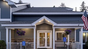 Un bâtiment doté d’une entrée fermée par un portail, d’un panneau indiquant qu’il est accessible aux personnes à mobilité réduite et arborant le drapeau américain.