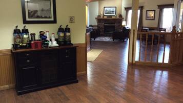 A hotel lobby with a fireplace, seating area, and a coffee station.