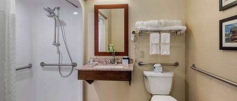 Une salle de bain équipée d’une douche, de toilettes, d’un meuble-lavabo et d’un porte-serviettes.