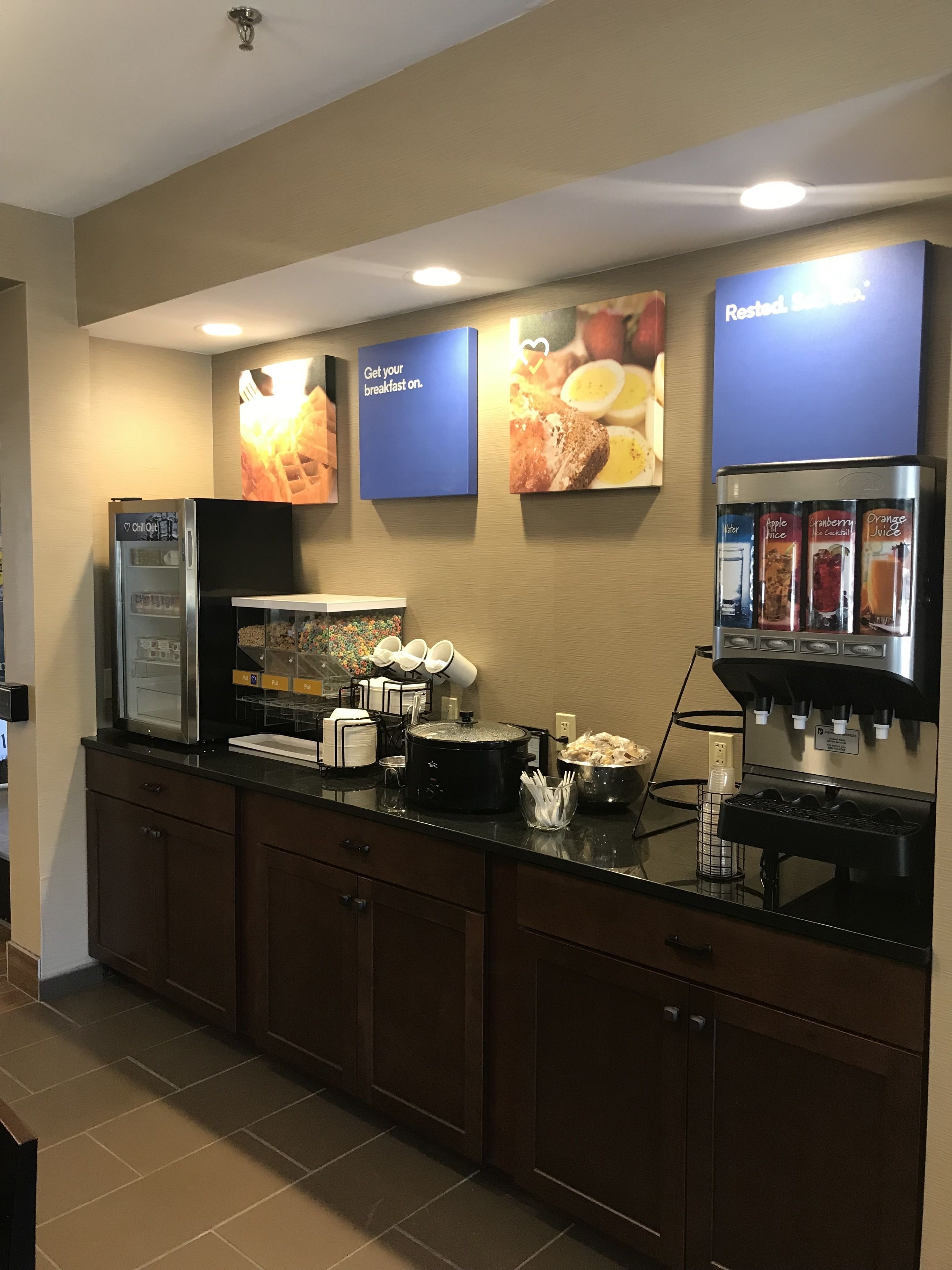 A breakfast bar with a refrigerator, coffee machine, and a slow cooker.