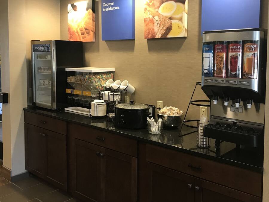 A breakfast bar with a refrigerator, coffee machine, and a slow cooker.