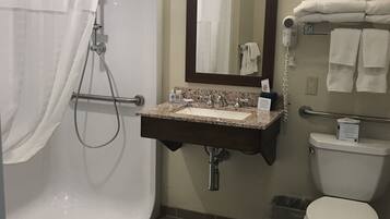 A bathroom with a shower, sink, and toilet.