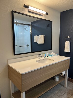 Een bad/douchecombinatie, designer toiletartikelen, een haardroger