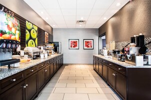 Una cocina moderna con una isla central, una máquina de café y un dispensador de jugo.