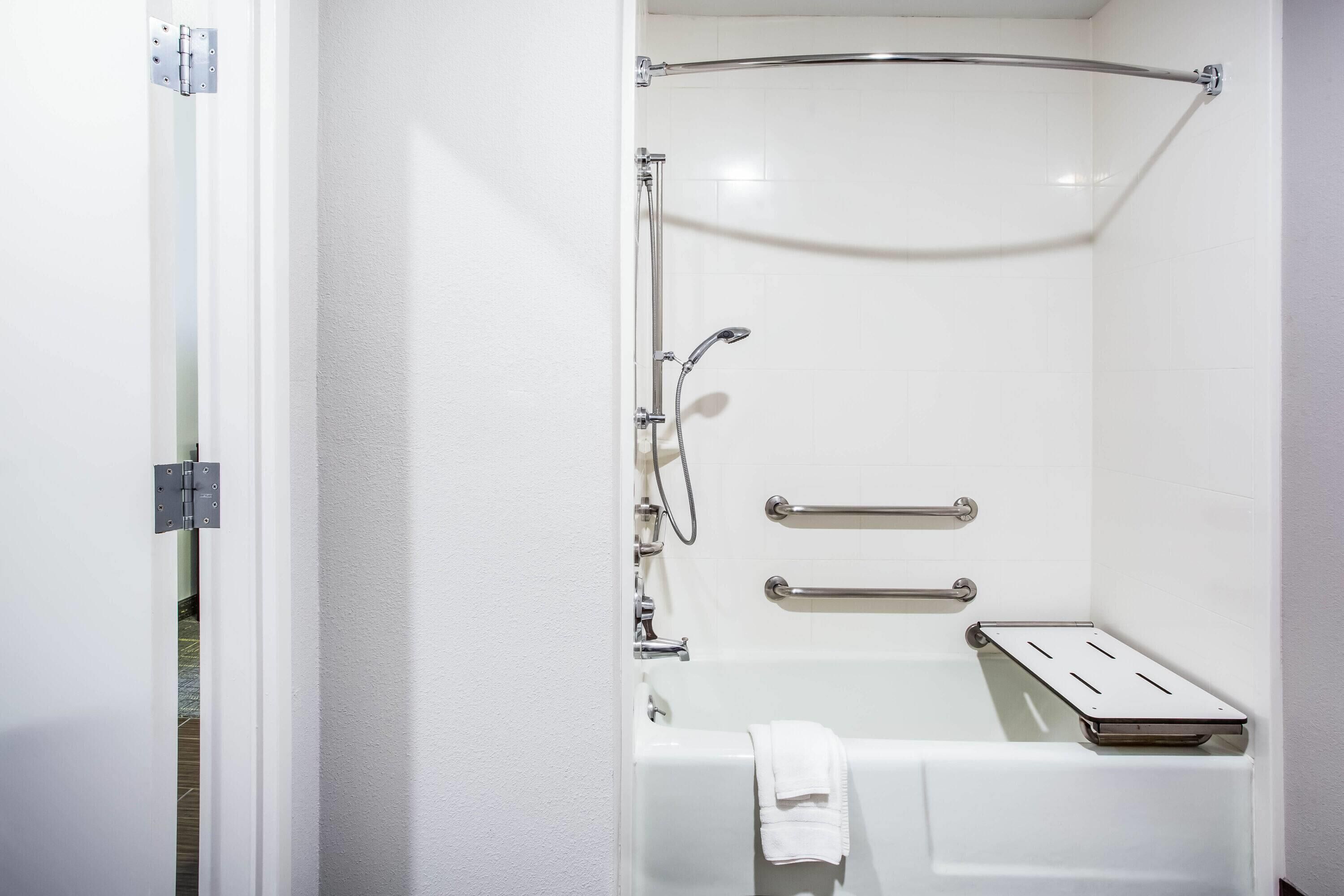 Un baño con bañera, ducha y barra para toallas.