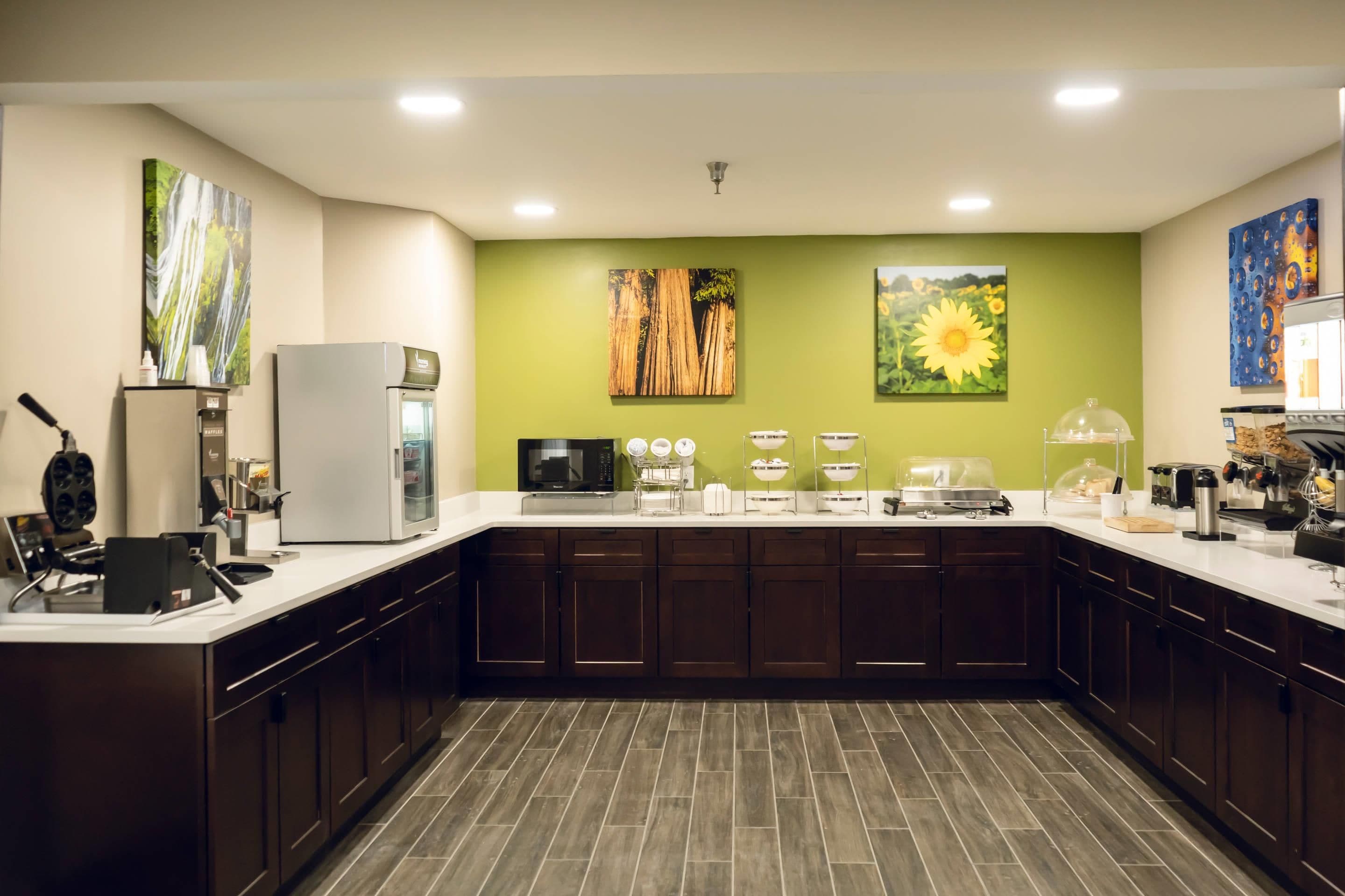 Cozinha moderna com ilha central, equipada com diversos eletrodomésticos e um espaço para café.
