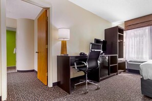 A hotel room with a desk, chair, lamp, TV, wardrobe, and a bed. - Sleep Inn & Suites Omaha Airport (Omaha)