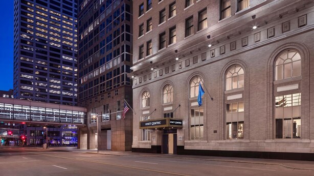 Un hôtel à la façade classique, doté de grandes fenêtres et d’une enseigne indiquant « Hyatt Centric ».