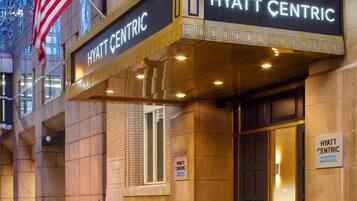 Das Hyatt Centric Hotel mit klassischer Fassade, großen Eingangstüren und einer amerikanischen Flagge.