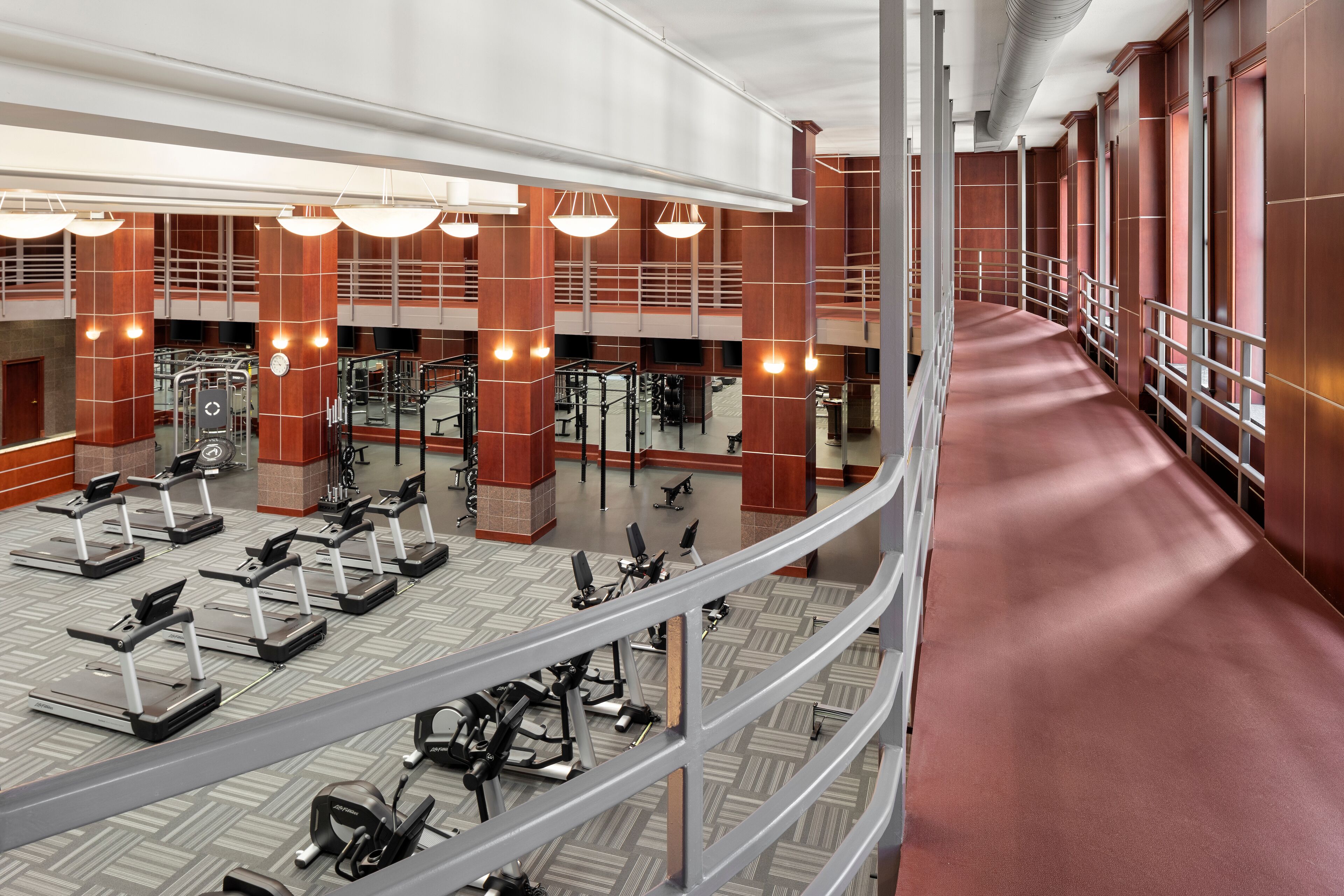 A multi-level gym with treadmills, weight machines, and exercise equipment.