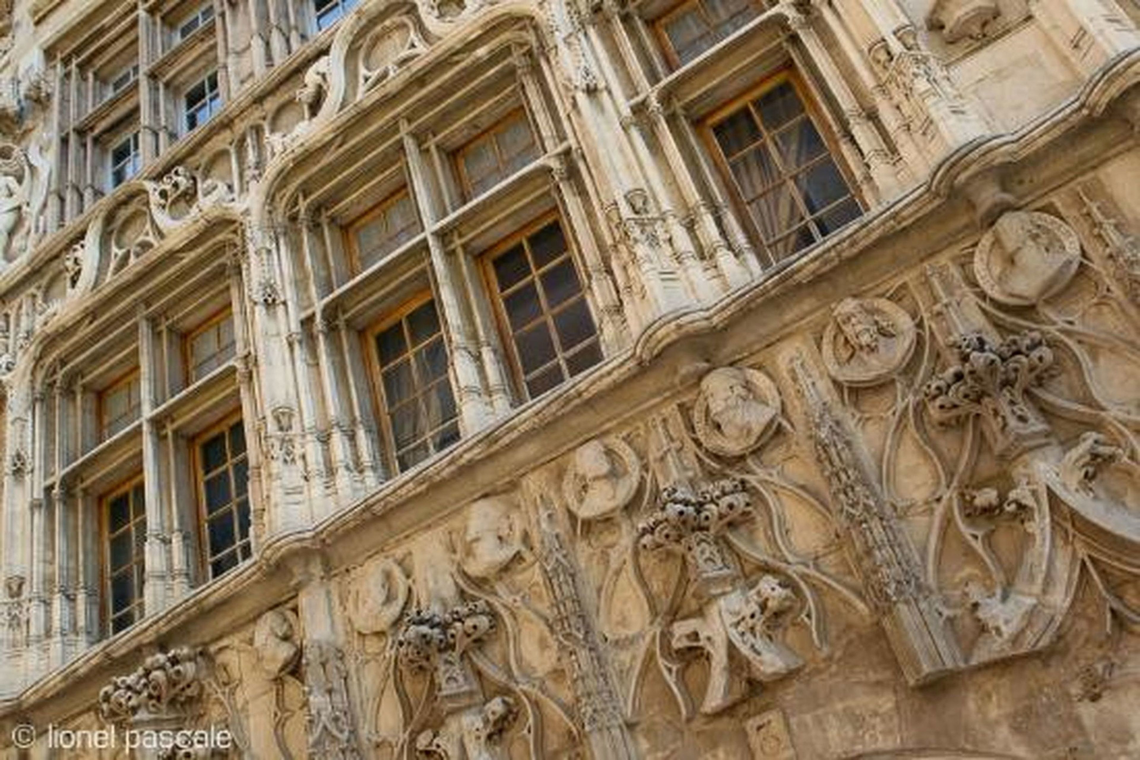 A building facade with ornate architectural details, including sculptural elements and classical window designs.
