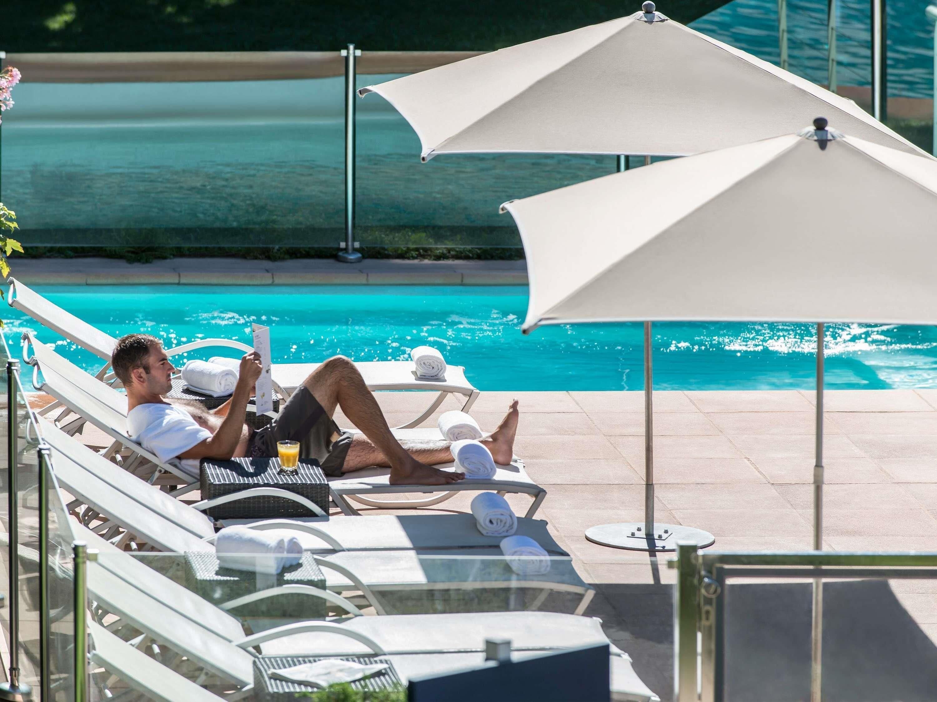 Een seizoensgebonden buitenzwembad en parasols bij het zwembad