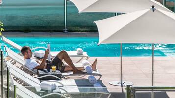 Een seizoensgebonden buitenzwembad en parasols bij het zwembad